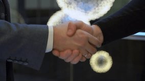 In a modern office, two businessmen shake hands to seal a deal, surrounded by elegant lighting and a formal atmosphere. The agreement signifies success in their business partnership - Powered by Shutterstock - Get 15% off with code: PIKWIZARD15