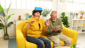Senior woman using virtual reality googles next to her husband sitting on the sofa using mobile phone - Powered by Shutterstock - Get 15% off with code: PIKWIZARD15