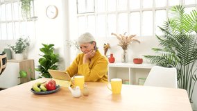 Happy caucasian modern senior couple surfing the net using digital tablet at home - Powered by Shutterstock - Get 15% off with code: PIKWIZARD15