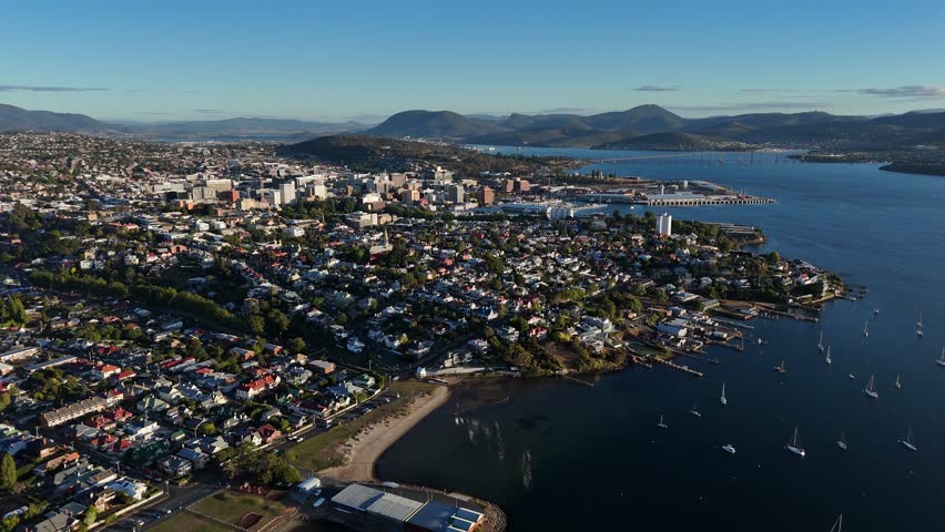 Harbor of Hobart city with mountains in background in Tasmania, drone shot high altitude