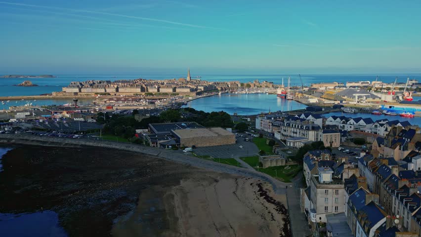 Les Bas Sablons plage in smooth receding drone movement, Intra Muros in background. Saint-Malo, Brittany in France.