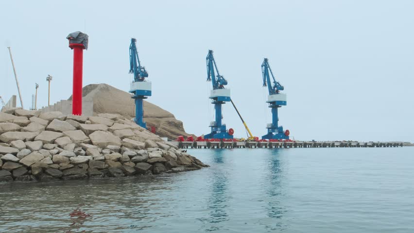 A blue and white harbor with a large crane in the middle