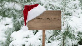Santa hat on wooden road sign, nature background with pine trees and snowy forest. Concept of Christmas holiday and happy New Year. Winter nature. Signboard with red hat - Powered by Shutterstock - Get 15% off with code: PIKWIZARD15