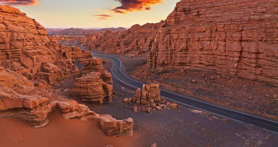 Spectacular Yardang landform mountain and road landscape at sunrise. The famous Dahaidao natural landscape in Xinjiang, China.