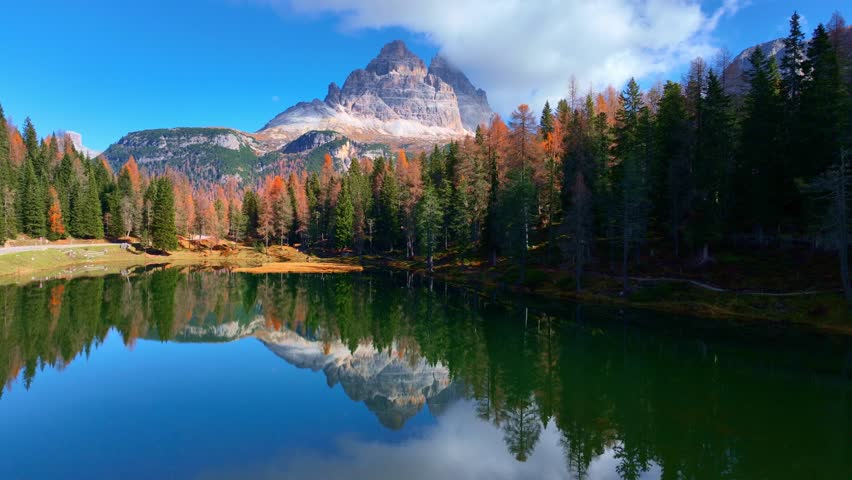 Establishing drone view of autumn in the Dolomites in Italy, beautiful lake Antorno in the Dolomite mountains, Tre Cime di Lavaredo national park in Italy in autumn. High quality 4k footage