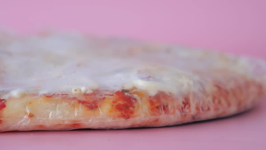 Delicious Frozen Pizza Featuring Cheese and Various Toppings, All Wrapped Securely in Plastic