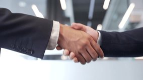 Close up of business handshake symbolizing teamwork and cooperation. Two male professionals shaking hands after sealing a deal in a modern office. Concept of partnership among colleagues. Mutual trust - Powered by Shutterstock - Get 15% off with code: PIKWIZARD15