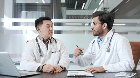 Two doctors collaborating in office, discussing medical strategies and patient care plans during a meeting. Medical workers physicians consult about further treatment of patients, communicate, advise - Powered by Shutterstock - Get 15% off with code: PIKWIZARD15