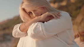 Close up of a beautiful young blonde woman with green eyes and a white dress looking at the camera and smiling on a warm summer evening during golden hour. - Powered by Shutterstock - Get 15% off with code: PIKWIZARD15