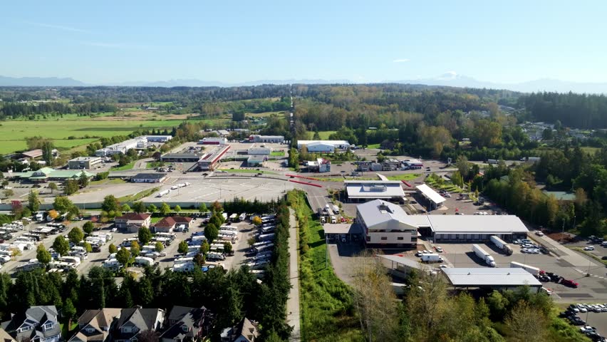 Vehicles Navigate Through Several Checkpoint Lanes at the Bustling Border Crossing Between South Surrey, BC, and Blaine, WA - Drone Flying Forward