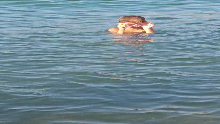 A boy dives into the water on the sea beach