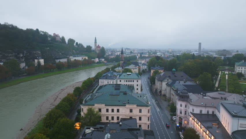 High angle perspective of Salzburg, Austria, with the Salzach River winding through the cityscape. Scenic panoramas highlight the blend of historic architecture and natural beauty