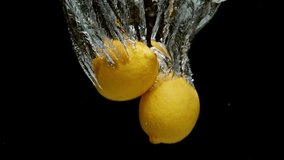 two lemons in sinking motion underwater leaving a trail of bubbles behind on black background and in slow motion - Powered by Shutterstock - Get 15% off with code: PIKWIZARD15