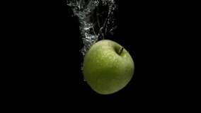 a green apple sinking fast in water creating bubbles on black background and in slow motion - Powered by Shutterstock - Get 15% off with code: PIKWIZARD15