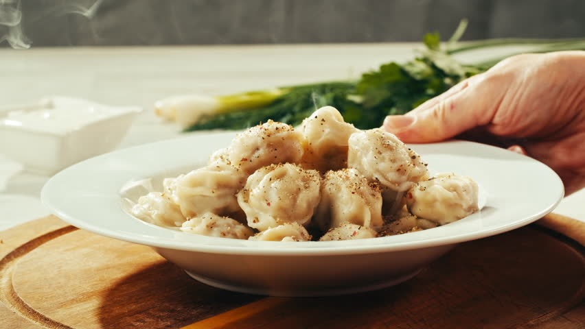 Dumplings in cafe, close up, Eating and serving Meat frozen dumplings in restaurant with mayo sour cream sauce, Ukranian, polish, Russian traditional pelmeni cooking process, vareniki ravioli pierogi