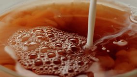 Pouring milk into black english breakfast tea in glass cup. Drinking hot tea with milk, healthy morning, freshly brewed detox drink. - Powered by Shutterstock - Get 15% off with code: PIKWIZARD15