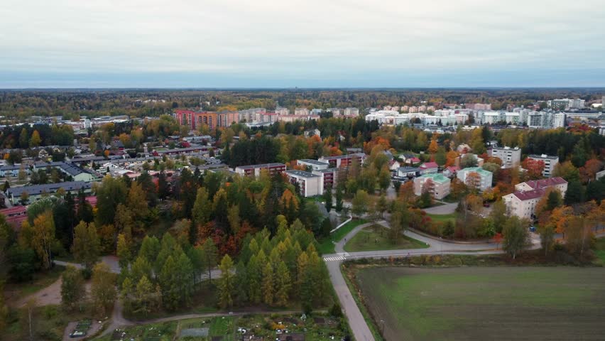 Golden autumn trees brighten northern city in autumn, aerial view