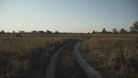 Man walks his mountain bike down dirt road at sunset, surrounded by golden fields and nature. With backpack and view of back, he moves through tranquil landscape, embracing freedom of outdoors.  - Powered by Shutterstock - Get 15% off with code: PIKWIZARD15