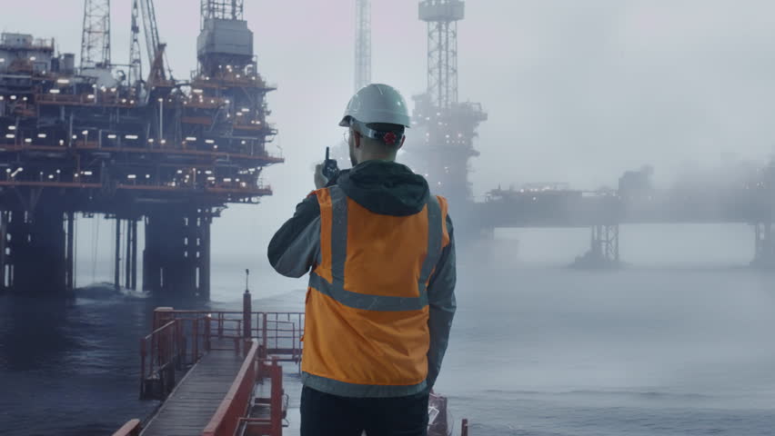 Oil Rig Worker In Safety Gear Observing Offshore Platform Foggy Morning Industrial Scene