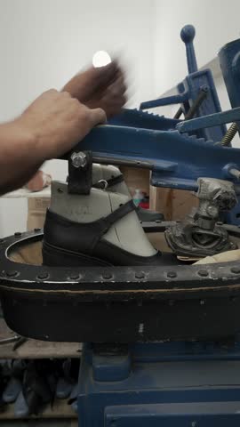 Sealing process, veteran shoemaker in his workshop in Colombia.