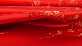 Lustrous red silk textile fabric background with floral golden embroidery in oriental style with plum blossom flower pattern. Soft folds of brocade shimmers beautifully on a rotating display case.  - Powered by Shutterstock - Get 15% off with code: PIKWIZARD15