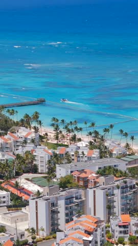 Vertical aerial view of Los Corales Bavaro beach. Residential buildings on the shore of the turquoise Caribbean sea. Apartments for Short-Term rent in Dominican Republic