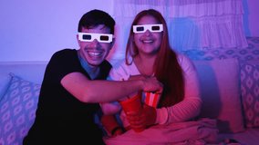 Young happy couple eating popcorn and drinking soda with 3D glasses at home in the evening, home cinema concept - Powered by Shutterstock - Get 15% off with code: PIKWIZARD15