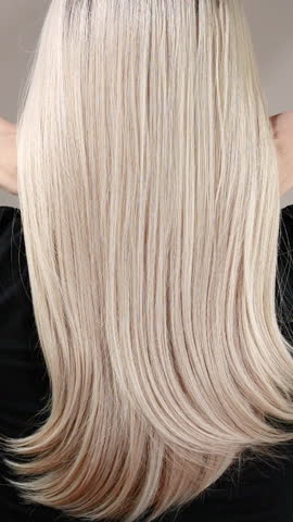 Vertical slow motion video of unrecognizable model with long blond straight hair