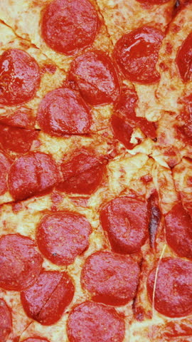 A close-up of three delicious slices of pepperoni pizza being lifted from an open box containing a whole pepperoni pizza, showcasing cheesy goodness and vibrant toppings