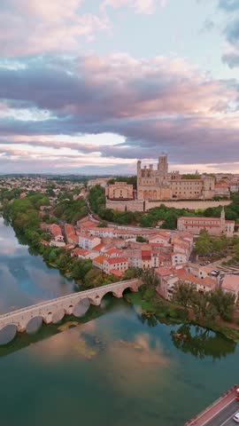 The old bridge over the Orb river with the Cathedral of Saint Nazaire in Beziers at sunrise, Southern France. Aerial view of the Beziers old town in France.