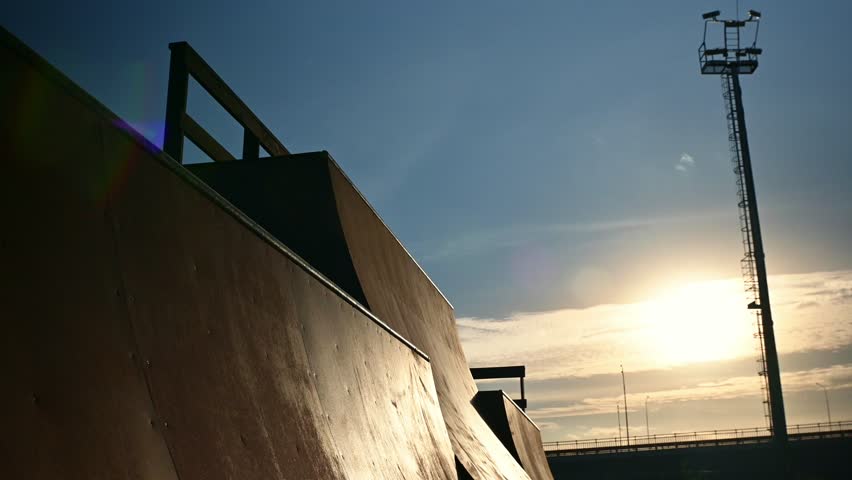 The athlete actively spends time at sunset. A cyclist rides on trampolines . A stuntman performs stunts on a bmx bike