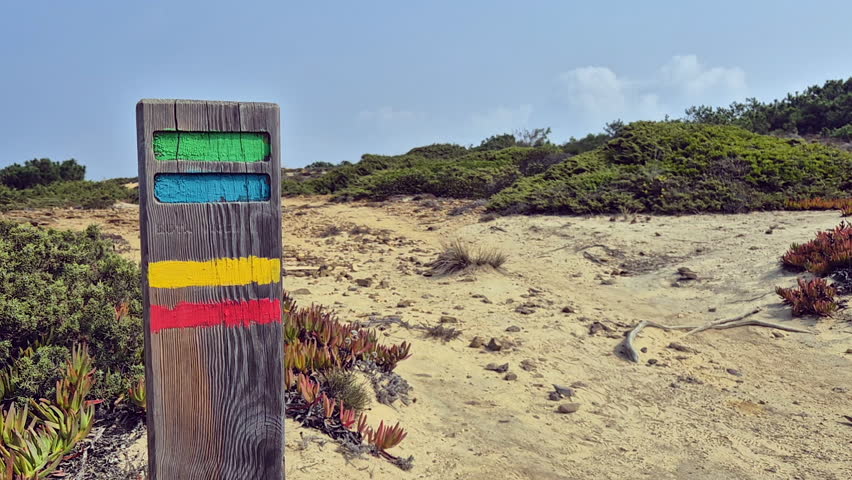 Female backpacker touches trail marker on Fisherman