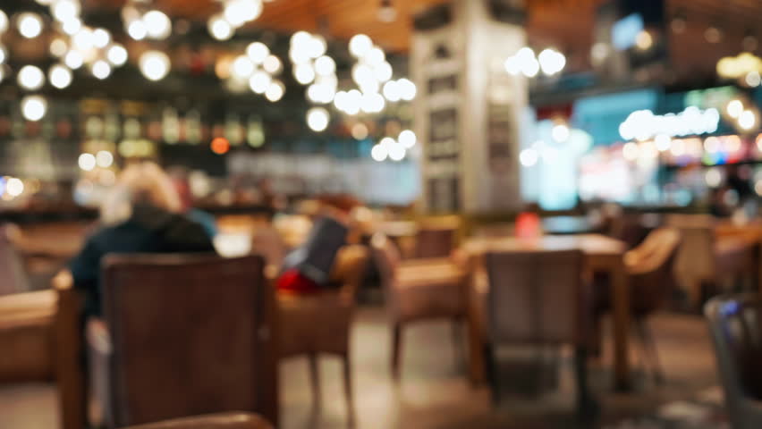 Blurred cozy stylish restaurant interior with warm ambient lighting empty tables. Soft bokeh effect highlights relaxed atmosphere perfect for social gatherings quiet moments. Food drink people