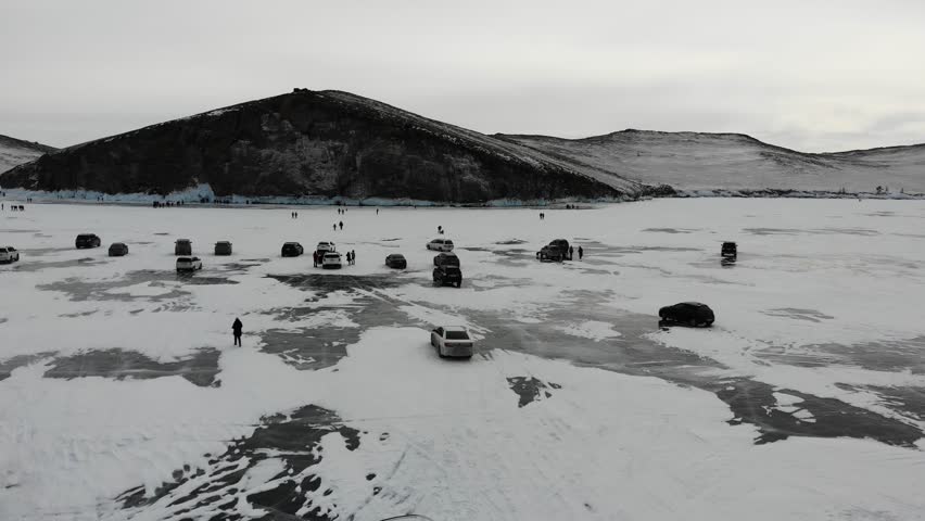 Cars and tourists on the ice of the frozen Lake Baikal. 
