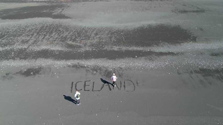 Aerial view of black sand beach in Iceland. Inscription on the sand of Iceland in the beautiful nature of the tourist island. High quality 4k footage
