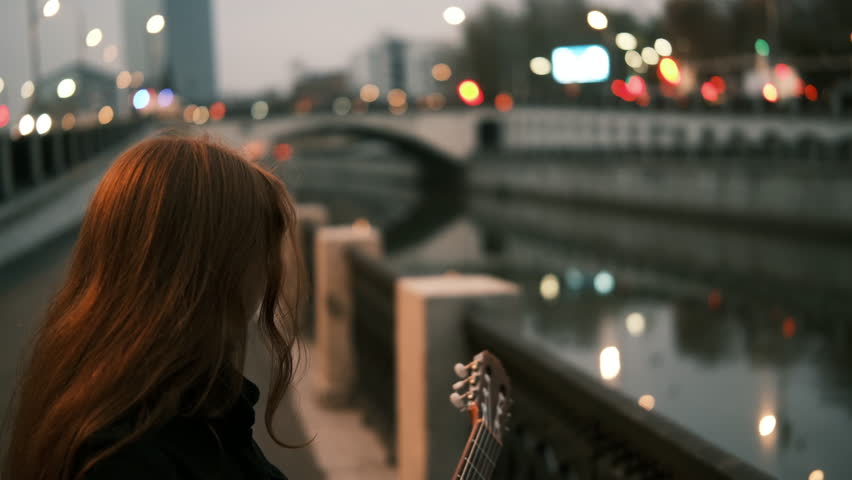 girl with guitar in the city. close-up, portrait, cinematic. autumn, cityscape bridge, old town. girl musician with red hair. Music lifestyle concept. 