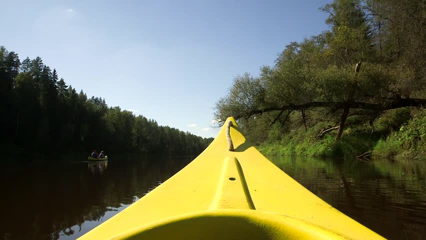 The Prow of the Yellow Boat Passes Under a Fallen Tree Driving Down the River. Canoes are Popular on Rivers Due to Their Carrying Capacity and Efficiency on the Water. They are Also Easy to Portage.