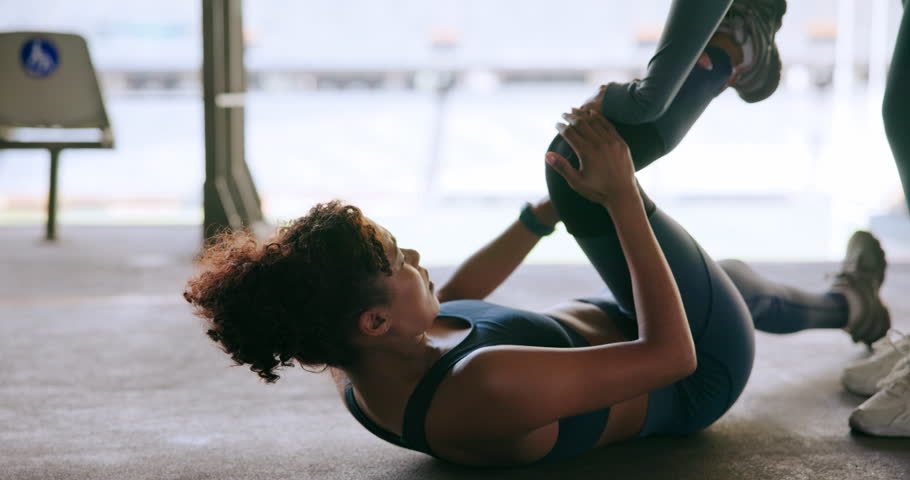 Woman, fitness and knee injury with personal trainer for pain, sprain or muscle tension at stadium. Female person, athlete or coach helping runner with sore leg, joint or bone for accident or workout