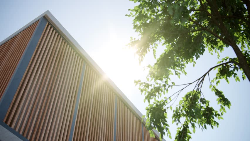 Stylish modern house exterior completed with wooden fluted panels and glass balcony with blue sky on background. Minimalistic decorative touches on building. Golden hours