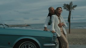 Couple Shares Joyful Moment By Seaside Leaning Against Their Classic Car. - Powered by Shutterstock - Get 15% off with code: PIKWIZARD15