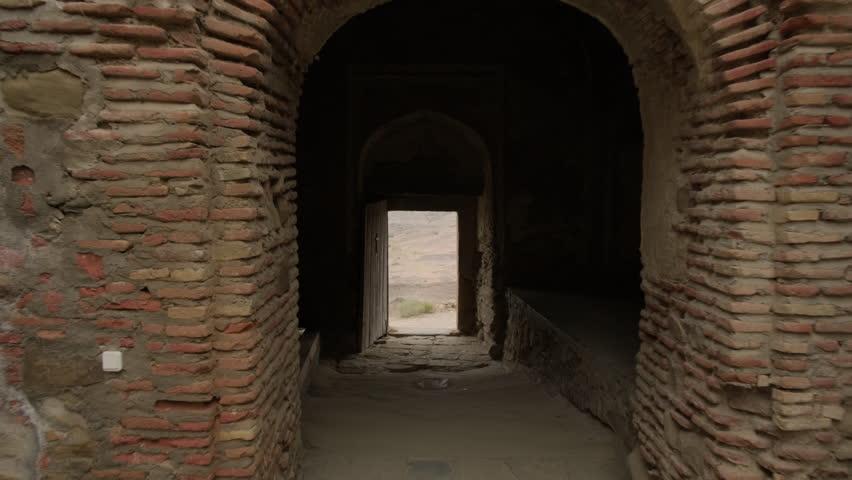 Walking towards open doorway onto captivating nature from dark room.