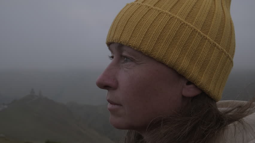 Portrait of woman looking at sky in mountains.