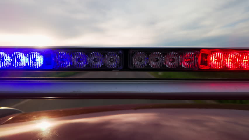 Police patrol car with flashing special signal rushes along road.