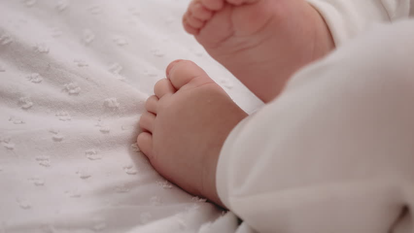 Tiny feet close up of newborn child boy not wearing socks and moving them really fast. Macro shot of pretty infant feet. Infancy, childhood, development, summer holiday, lifestyle concept