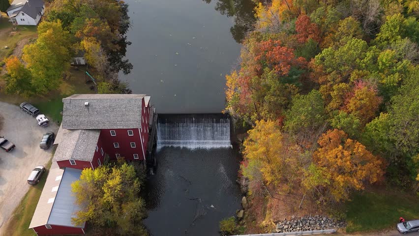 Drone view of grain mill on quiet pond during autumn