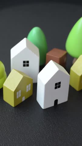 A small wooden house and keys as an idea for investing in your own home and achieving the goal of buying real estate. Background for your idea