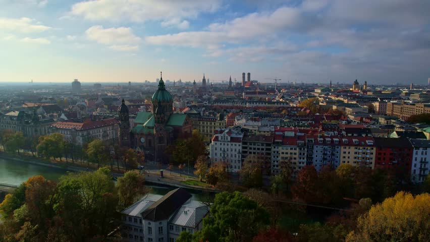 4K Aerial Drone video of beautiful autumn in city center Munich with Isar river, Saint Lukas church, Marienplatz and Maximilianeum on a sunny warm day, Germany
