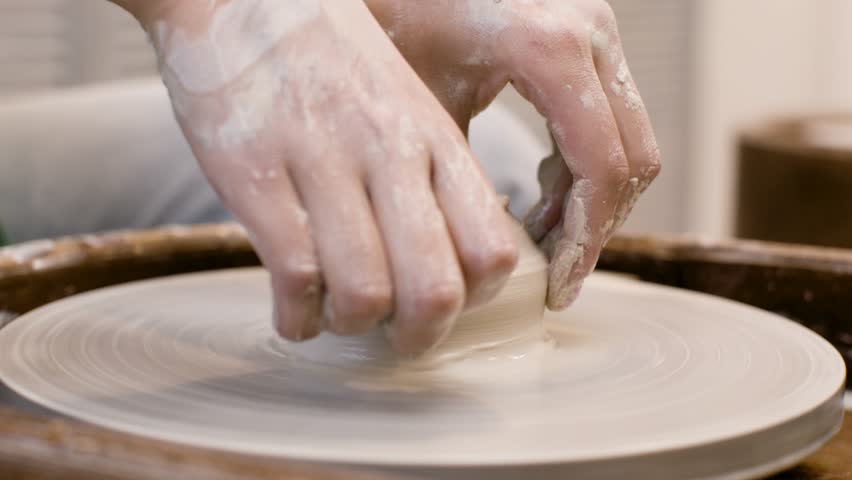 Hands Of A Clerk Modeling Ceramic Piece On A Potter Wheel In A Workshop. Woman Hands Shaping Mound of Clay on Potter Wheel During Pottery Workshop. Potter shapes clay product. Arts and crafts