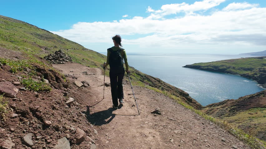Young woman walking on narrow trail at Ponta de Sao Lourenco in Madeira Island, Portugal