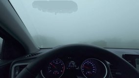 Car driving along narrow road in dense heavy fog, creating dangerous driving conditions - Powered by Shutterstock - Get 15% off with code: PIKWIZARD15